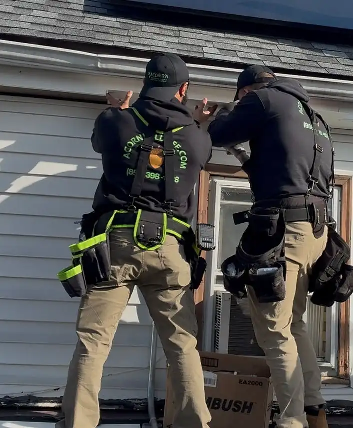 Acorn technicians on a ladder sealing an upper-floor entry